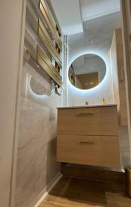 a bathroom with a wooden vanity and a mirror at Le Nid douillet- Studio Chic au cœur Issoire in Issoire