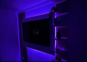a living room with purple lights on a tv at Le Nid douillet- Studio Chic au cœur Issoire in Issoire