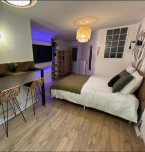 a bedroom with a bed and a desk and a kitchen at Le Nid douillet- Studio Chic au cœur Issoire in Issoire