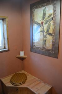 a toilet in a room with a painting on the wall at La Parenthèse Béarnaise in Bonnut +8 photos