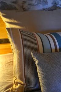 a pillow sitting on top of a bed next to a pillow at La Parenthèse Béarnaise in Bonnut