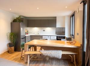 a large kitchen with a wooden table and chairs at Maison cosy à Cauterets avec vue sur les montagnes et jardin in Cauterets