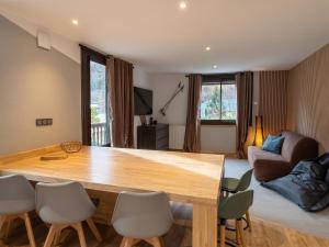 a living room with a wooden table and chairs at Maison cosy à Cauterets avec vue sur les montagnes et jardin in Cauterets +18 photos