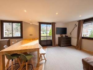 a living room with a wooden table and chairs at Maison cosy à Cauterets avec vue sur les montagnes et jardin in Cauterets
