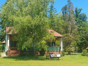 a house with a tree in front of it at Csiszárhegyi Vadászház in Karád