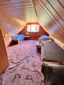 a room with two beds in a wooden house at Chata u řeky Svatavy in Josefov