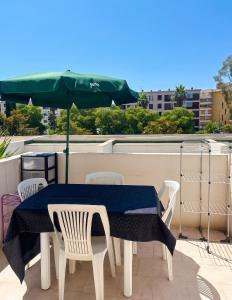 a table with chairs and an umbrella on a roof at Appartement moderne à Fréjus, 60 m², piscine partagée in Fréjus
