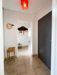 a hallway with a black door and a tiled floor at Appartement moderne à Fréjus, 60 m², piscine partagée in Fréjus