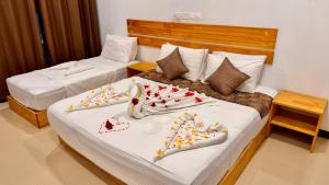 two beds in a hotel room with food on them at Celeste Thoddoo Maldives in Thoddoo