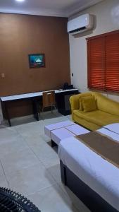 a living room with a bed and a couch at Posh Hotelia in Hausa
