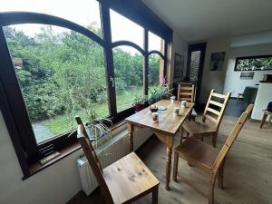 a dining room with a table and chairs and a large window at Hooiland's Hof in Diest