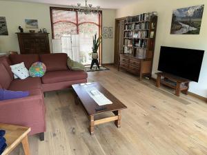 a living room with a couch and a tv at Hooiland's Hof in Diest