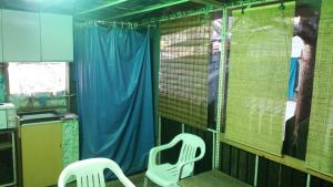 two white chairs in a kitchen with a blue curtain at Gradishte beach Ohrid in Ohrid +7 photos