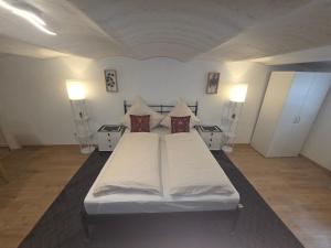 ein weißes Bett in einem Zimmer mit zwei Nachttischen in der Unterkunft Panoramic Hause in Uttenweiler