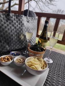 a table with food and a bottle of wine and glasses at Csiszárhegyi Vadászház in Karád