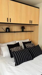 a bed with black and white pillows on it at La Casina - Centro Colere - 600mt dagli impianti in Colere
