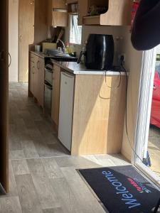 a kitchen with wooden cabinets and a kitchen rug on the floor at 159 cambersands in Hastings