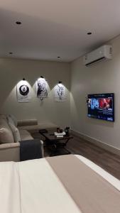 a living room with a bed and a tv at استديو in Al Khobar