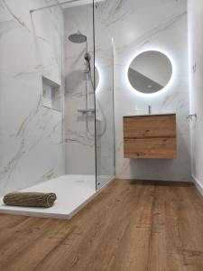a bathroom with a shower with a sink and a mirror at Sardina Beach Retreat in Gáldar