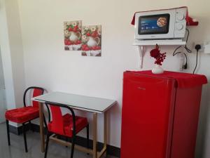 a room with a small table and a tv on top of a refrigerator at Vue de Vallee in Port Louis