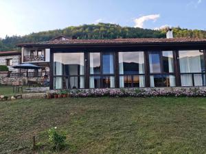 a house with large windows and a yard at Villa Vera in Smilyan