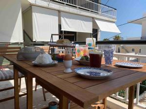 a wooden table with plates of food on a patio at Veranda Agia Marina in Agia Marina Aegina