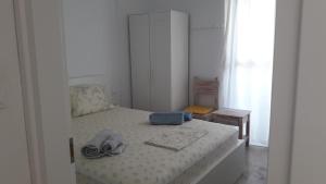 a small bedroom with a bed with shoes on it at Veranda Agia Marina in Agia Marina Aegina