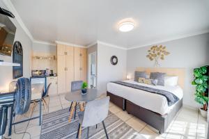 a bedroom with a bed and a table and a kitchen at 16 Vaalrivier in Secunda