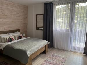 a bedroom with a bed and a large window at MONTANA in Jahorina