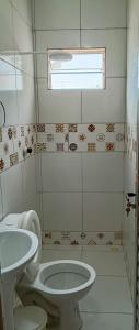 a bathroom with a toilet and a sink at Casa do Seu Lourenço in Beberibe