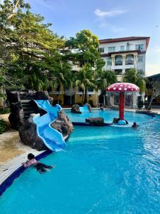 a pool at a resort with a water slide at Tiara Homestay Desaru - Garden Pool View in Bandar Penawar +12 photos