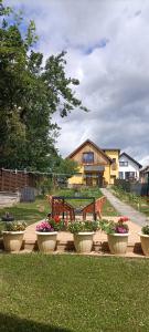 a group of flower pots in a yard with a house at Ubytovanie Gerlachov - Anna Bajzikova in Svätý Jur