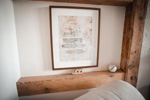 a picture hanging on a wall above a wooden shelf at Agroturystyka Czułe Miejsce in Zdory