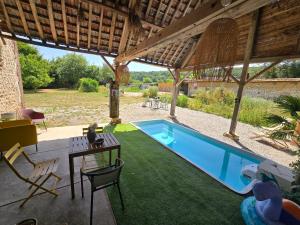 a pool in a house with a table and chairs at La Hacienda Verde in Heudreville-sur-Eure