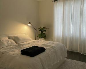 a bedroom with a white bed with a black bag on it at 2 bedrooms living apartments in Lahore