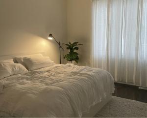 a bedroom with a white bed and a plant at 2 bedrooms living apartments in Lahore +12 photos