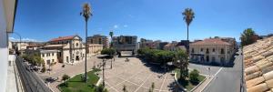 a city street with buildings and a plaza with palm trees at Giué in Bovalino Marina
