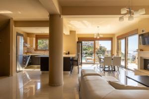 a living room and kitchen with a couch and a table at Villa Mononaftis in Agia Pelagia