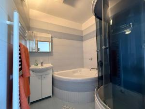 a bathroom with a tub and a toilet and a sink at Penzión Terno in Považská Bystrica