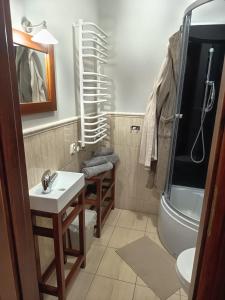 a bathroom with a sink and a toilet and a tub at Modrzewiowy Dworek in Mirzec