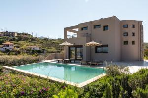 a villa with a swimming pool in front of a house at Villa Mononaftis in Agia Pelagia