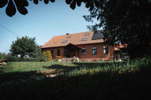 an old brick house with a red roof at Agroturystyka Czułe Miejsce in Zdory +57 photos