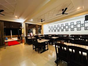 a dining room with tables and chairs in a restaurant at Emporia comforts in Devanhalli