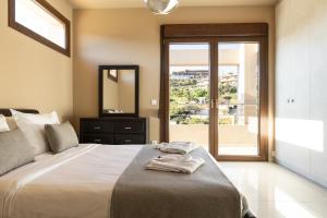 a bedroom with a bed with a mirror and a window at Villa Mononaftis in Agia Pelagia +19 photos