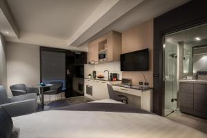 a hotel room with a bed and a desk with a laptop at Crest on Park in Melbourne
