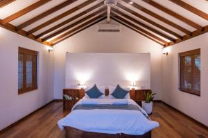 a bedroom with a large bed with blue pillows at Tropical Grove in Polgolla