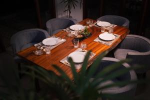 a wooden table with plates and glasses on it at Tropical Grove in Polgolla