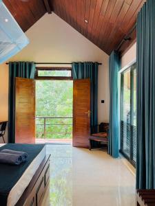 a bedroom with a bed and a large window at The Green View Yala in Tissamaharama