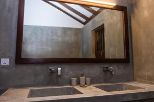 a bathroom with a sink and a large mirror at Tropical Grove in Polgolla +34 photos