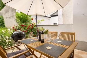 ein Holztisch mit Weingläsern und einem Sonnenschirm in der Unterkunft MOLA Apartments-Stilvolle Altstadtwohnung- Seilersee-5 Personen-Terrasse-Grill-Gratis WLAN in Iserlohn